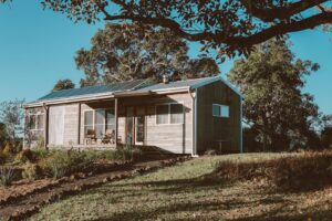 Wooden House With Solar Panels Near Green Trees
